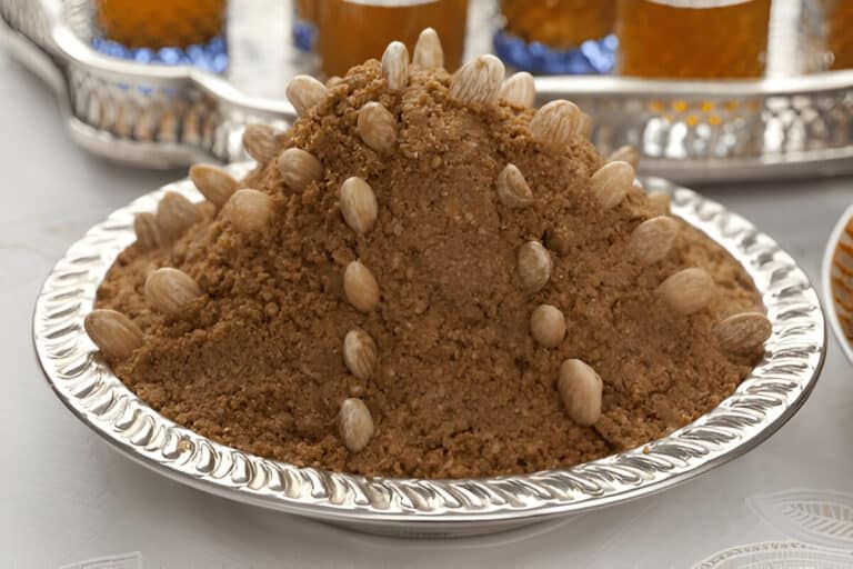 Monticule de sellou décoré d’amandes entières sur un plat marocain