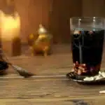 Verre de Jallab posé sur une table en bois avec des noix de cajou et une ambiance chaleureuse.