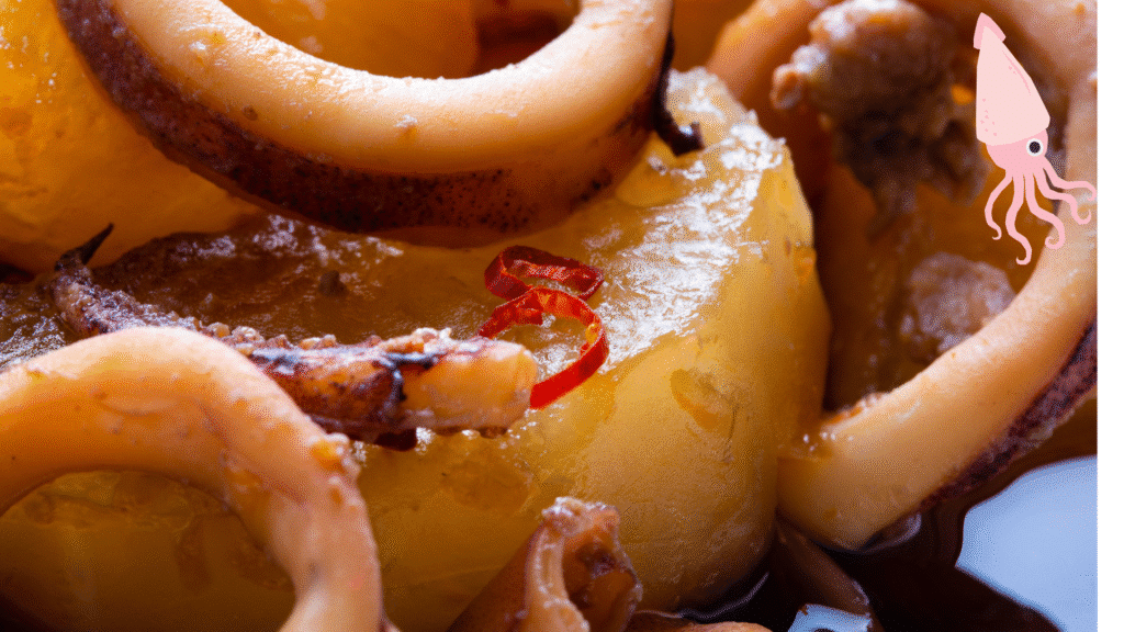 recette encornet Gros plan sur des encornets cuisinés avec des rondelles de piment rouge et pommes de terre fondantes, dans une sauce maison.