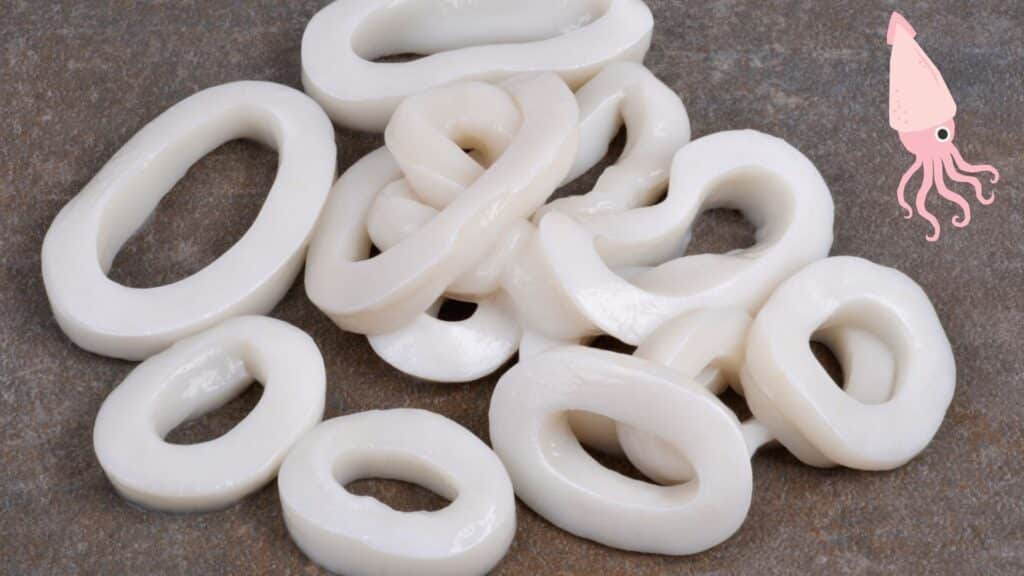 Anneaux d'encornet crus et frais, prêts à être cuisinés pour une recette de calamars à la plancha ou à la poêle.