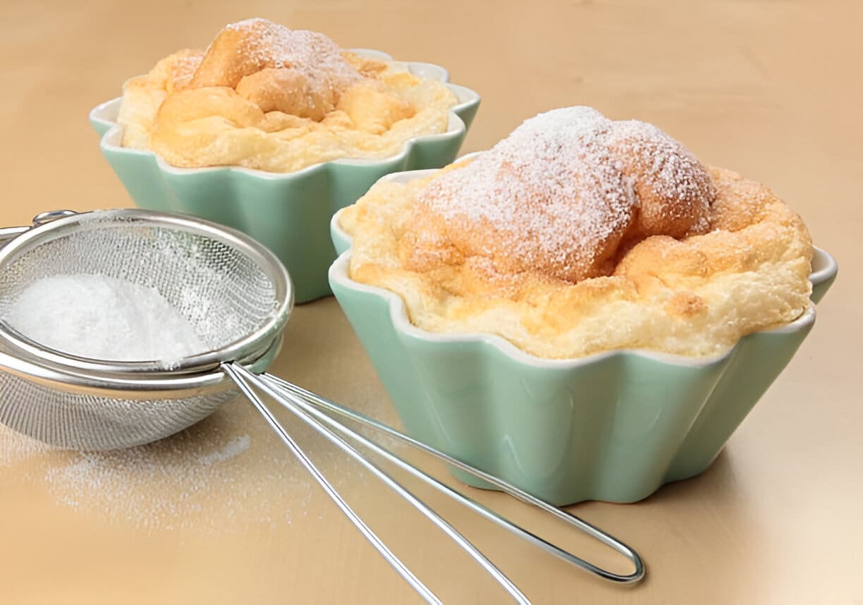 Soufflés nuage légers dans ramequins pastel Soufflés nuage moelleux saupoudrés de sucre glace