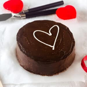 Bento cake au chocolat dans une boîte blanche, décoré d’un cœur en crème.